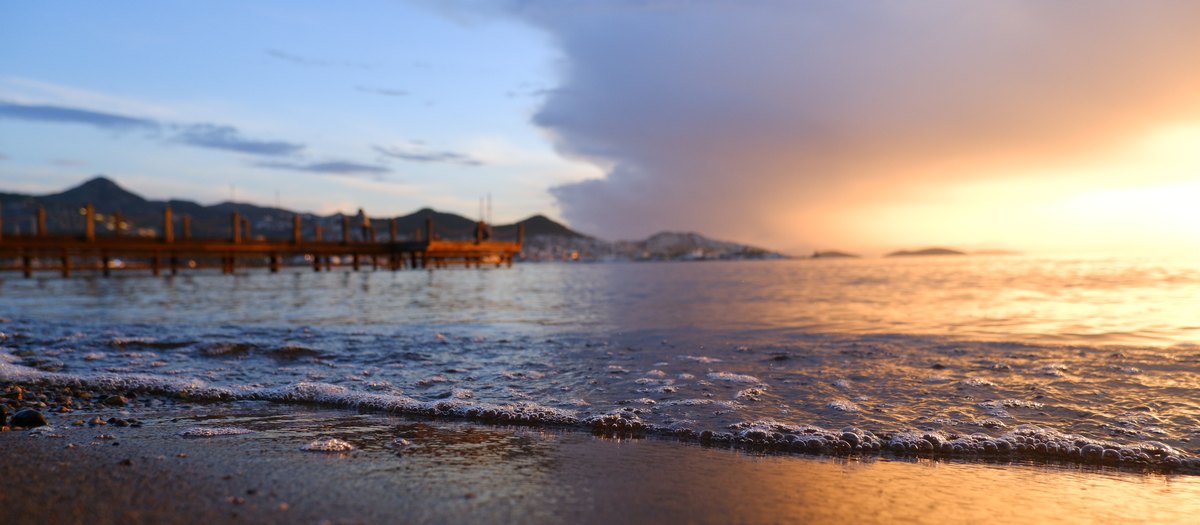 DSCF3345.JPG — golden hour beach with wooden pier, Bodrum. The real rejected file.